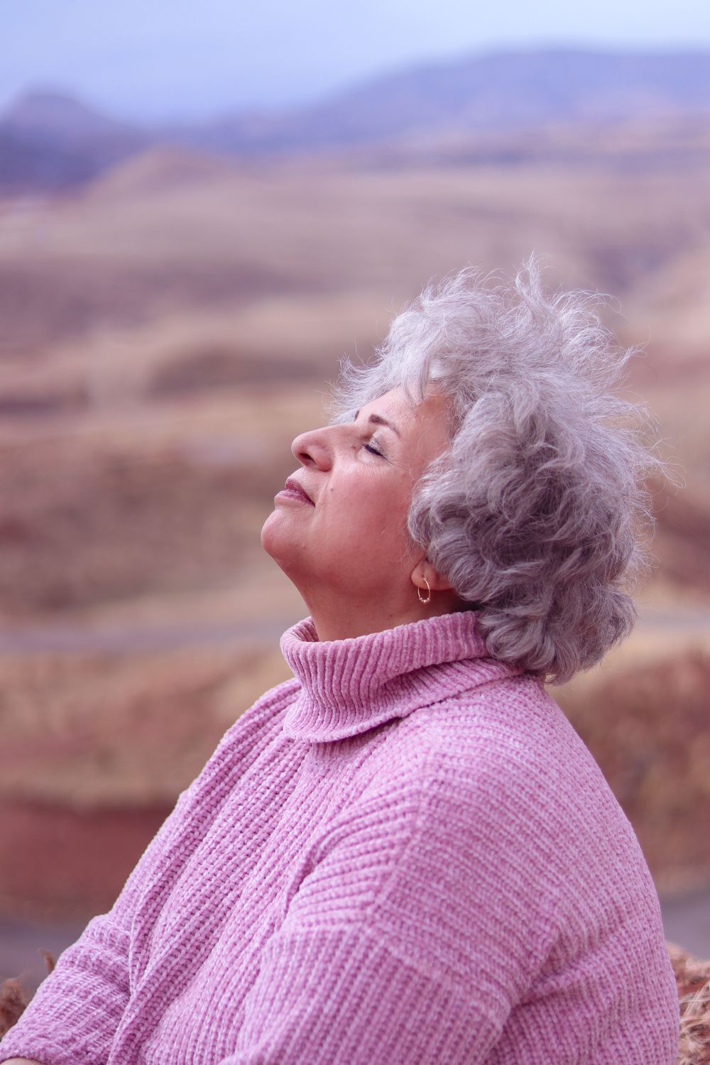 Woman breathing freely outdoors with her face turned up to the sky
