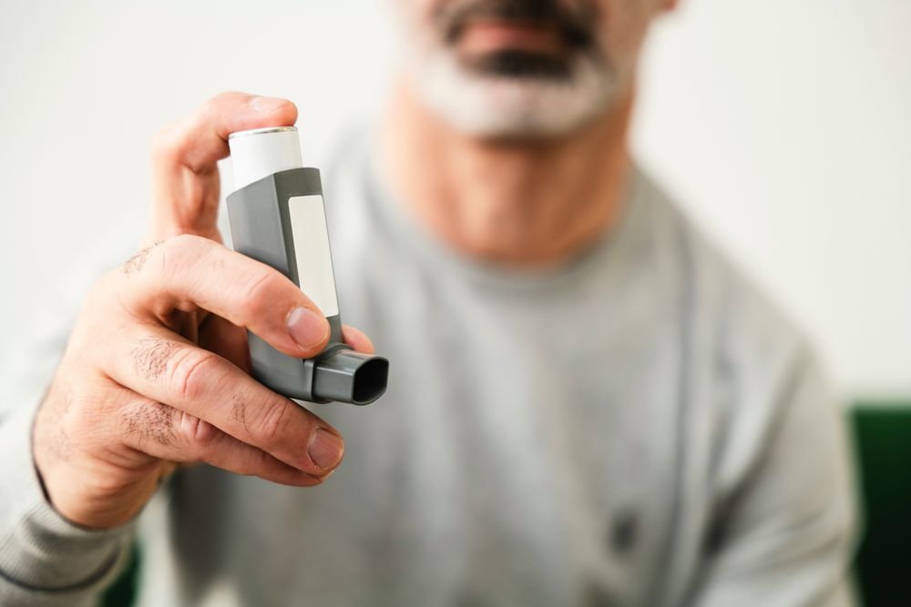 Man holding an inhaler, ready to manage his COPD